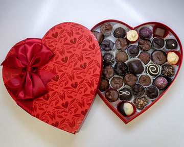 Shiny red heart box with bow and chocolates