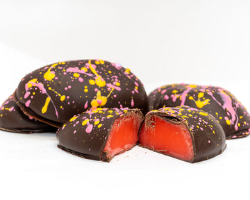 cross section of dark chocolate strawberry lemonade cream eggs with pink and yellow splatter design 